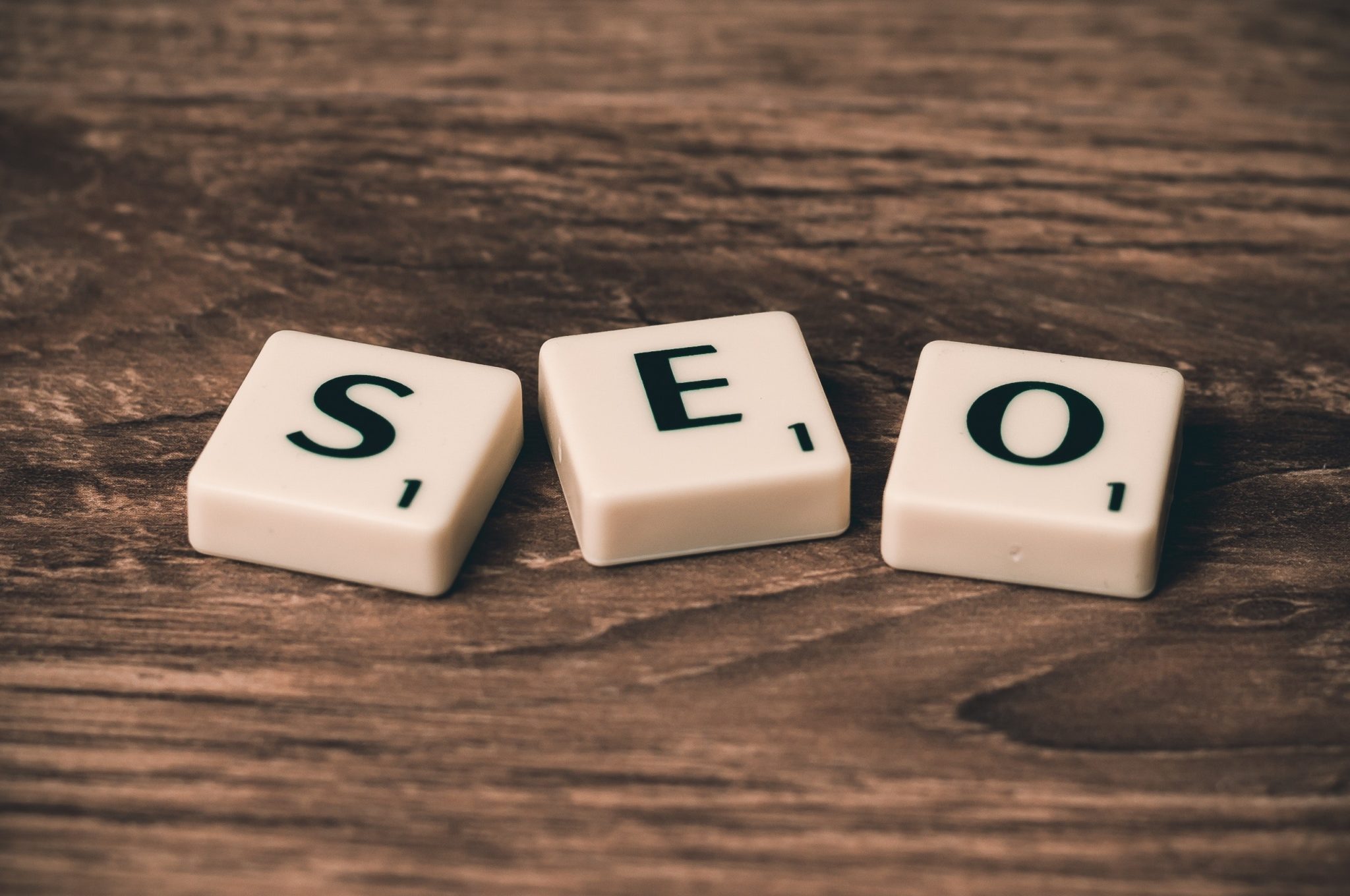 Scrabble tiles spelling SEO arranged on a wooden surface
