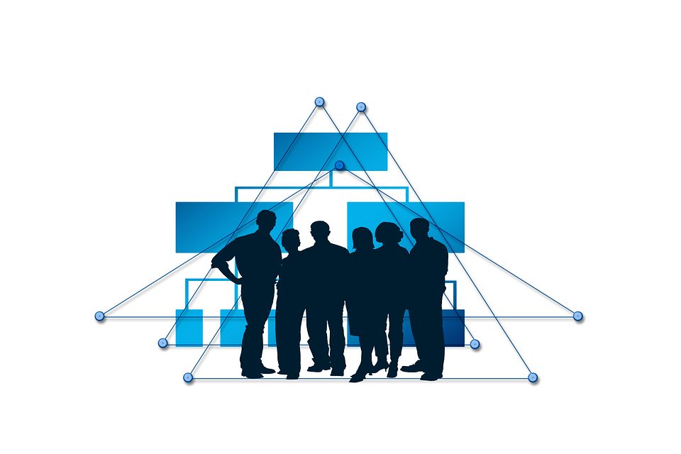 Silhouettes of people standing in front of a blue org-chart network diagram