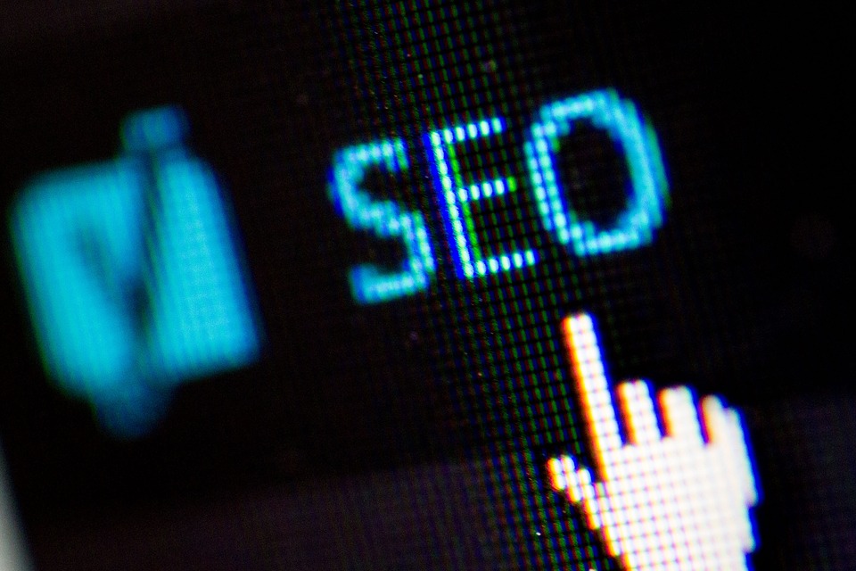 Close-up of a pixelated screen displaying the word SEO with a cursor hand icon