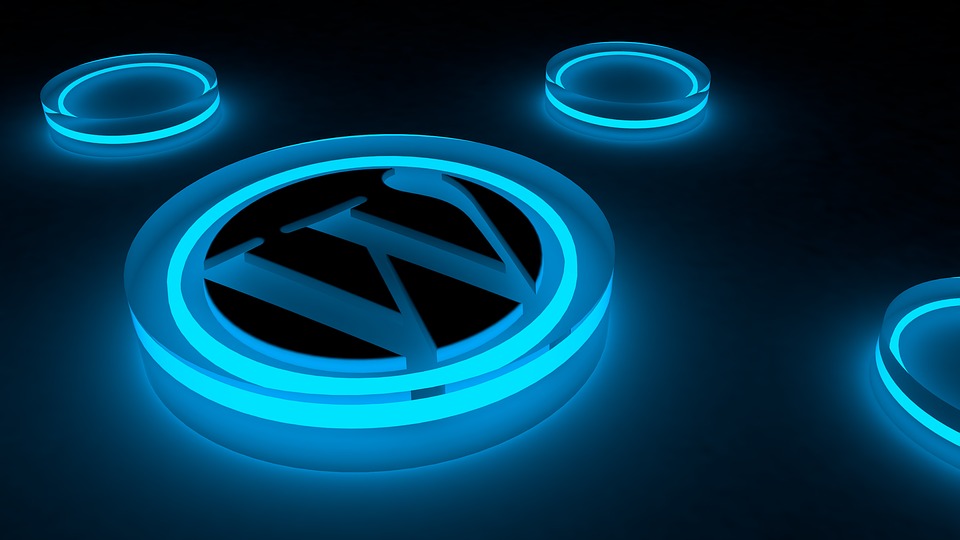 Glowing blue WordPress logo on a dark surface with smaller glowing rings around it