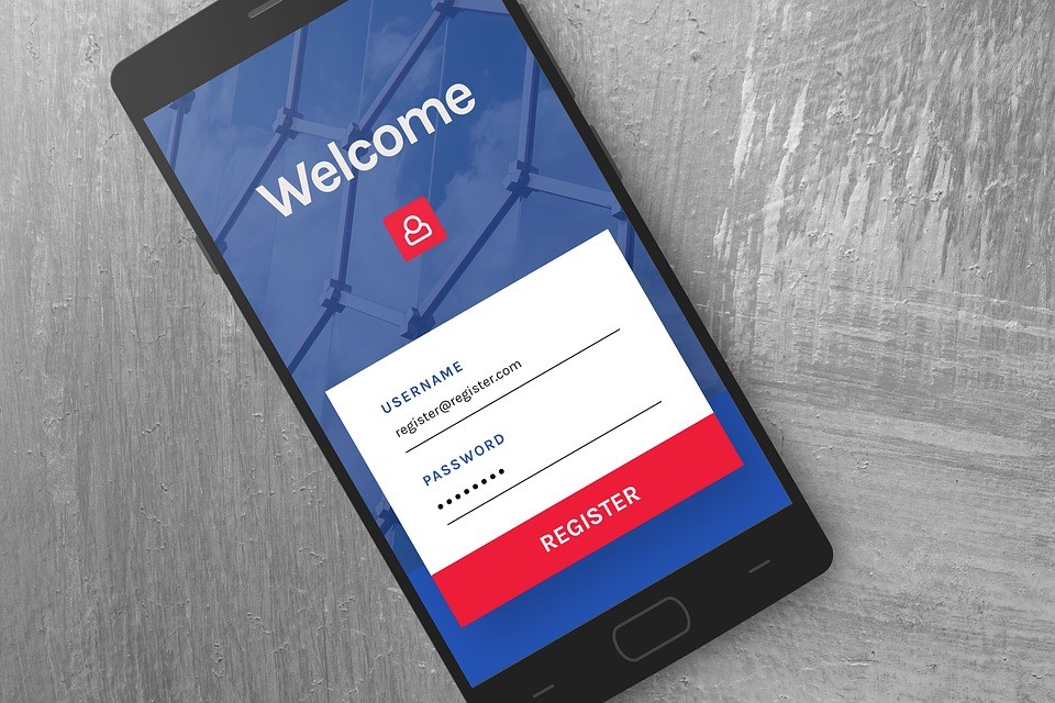 Smartphone on a concrete surface displaying a Welcome screen with username and password registration form