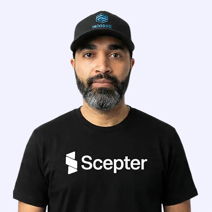 Bearded man in a Scepter cap and black Scepter t-shirt facing the camera